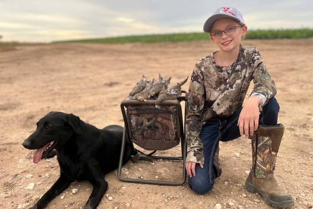 young girl and dog with doves after a hunt